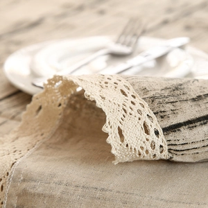 Close-up of wood grain printed tablecloth with intricate white crochet lace edge details