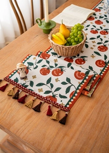 Close-up of tropical jacquard table runner with vintage leaf patterns and colorful tassels