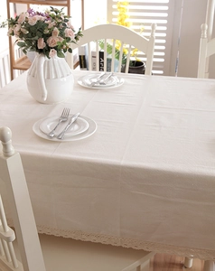Detalle de mantel rectangular beige con un sofisticado borde de encaje de ganchillo