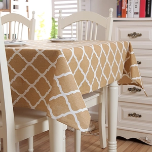 Detail of yellow geometric trellis pattern and hemmed edges on a poly-cotton tablecloth