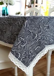 Detail of navy Japanese wave pattern tablecloth featuring white lace fringe edge