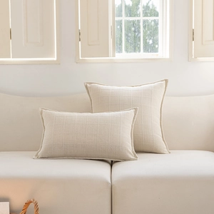 Detailed view of cream jacquard checkered cushion covers on a modern white sofa