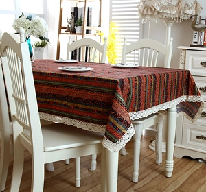 Macro detail of Bohemian striped linen tablecloth featuring white floral lace borders