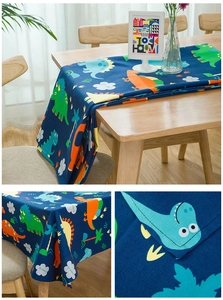Detail of thick cotton fabric with cute colorful cartoon dinosaur prints on dark blue base