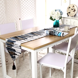 Detail of artistic abstract watercolor table runner featuring blue brushstrokes and brown tassels
