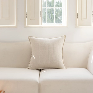 Detail of minimalist beige jacquard cushion cover with subtle woven grid pattern texture