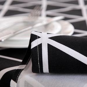 Close-up of geometric black and white cotton canvas tablecloth with dinnerware detail