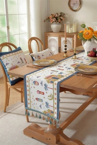 Close-up of woven Ramadan table runner with tassels featuring mosque and moon patterns