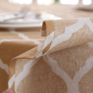 Close-up of yellow Moroccan geometric tablecloth with fine stitched edge and cotton texture