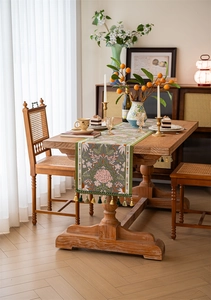 Detail of grey-green floral table runner with vintage jacquard patterns and elegant tassels