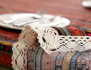 Detail of bohemian geometric table runner with intricate off-white lace borders