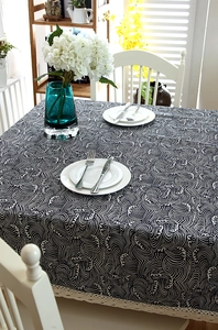 Detail of blue wave pattern tablecloth with white lace edges for dining table