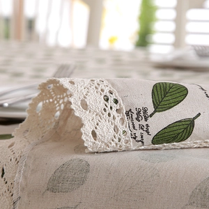 Detailed macro view of pastoral green leaf print tablecloth with crochet lace edge