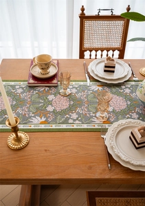 Detailed texture of jacquard floral table runner with pink hydrangeas on wooden table