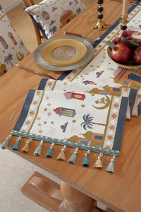 Detailed woven texture of Ramadan table runner with mosque patterns and gold tassels