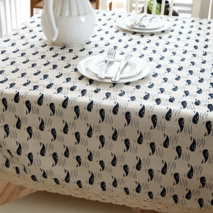 Modern linen tablecloth with blue whale print and white lace trim in a Nordic style setting