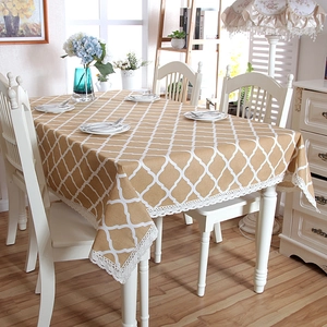 Detailed view of yellow geometric lattice tablecloth with white lace border and trim