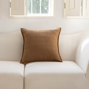 Detailed view of the textured caramel brown grid pattern on the square throw pillow cover