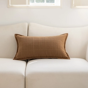 Macro detail of caramel brown waffle texture fabric on minimalist lumbar cushion cover