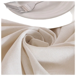 Mantel minimalista de algodón beige con encaje, textura tejida sobre plato blanco