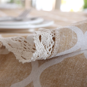 Detail of polyester cotton tablecloth featuring white lace edges and yellow diamond pattern