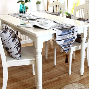 Detail of oil painting style striped table runner with brown tassels and cushion cover