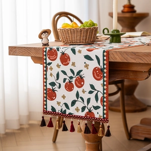 Tropical style woven table runner with red tomato patterns and elegant fringe tassels