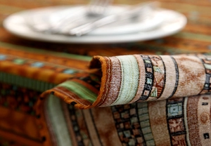 Close-up of ethnic style cotton linen tablecloth with woven texture and gold patterns