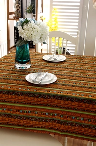 Close-up of bohemian linen tablecloth with gold-stamped stripes and lace edges