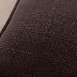 Macro shot of dark brown polyester cushion cover featuring textured jacquard square pattern