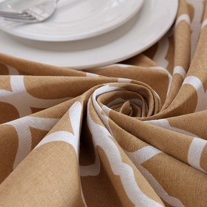 Detail of yellow cotton tablecloth with white geometric patterns and lace edging texture