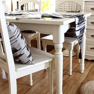 Detail of colorful striped table runner with brown tassels and matching pillow cover