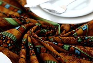 Detailed view of Southeast Asian style tablecloth with gold foil stripes and lace edge