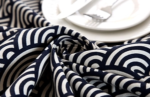 Detailed close-up of blue wave pattern cotton fabric with lace edge and soft texture