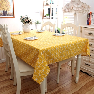 Close-up of modern yellow tablecloth with white geometric patterns in a bright dining room