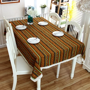 Detail of bohemian striped linen tablecloth featuring decorative white lace edges