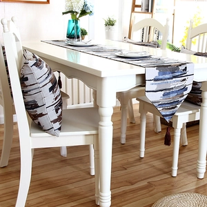 Detailed view of colorful striped table runner with tassels and matching pillow