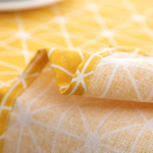 Close-up of yellow geometric plaid fabric with neat stitched edges for tablecloths