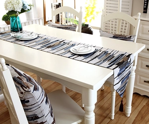 Detail of oil painting style striped table runner with matching pillow and tassels