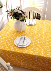 Close-up of yellow tablecloth featuring white geometric star patterns and smooth edges