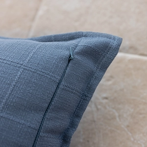 Detailed view of invisible zipper and textured blue jacquard fabric on throw pillow cover