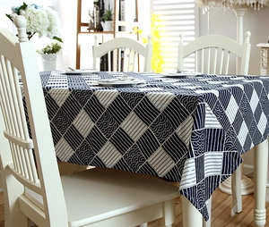 Detail of navy blue wave pattern tablecloth with white lace edges on a wooden table