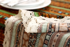 Detail shot of bohemian table runner featuring geometric gold stripes and lace borders