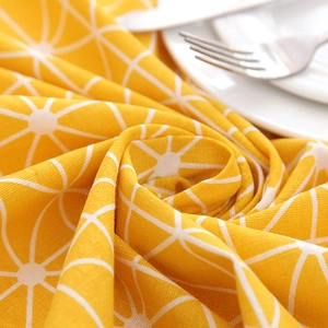 Detail of yellow tablecloth showing cotton linen texture with white geometric patterns