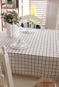 Detail der minimalistischen weiß-schwarz karierten Tischdecke auf einem Esstisch