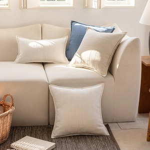 Minimalist checkered cushion covers in cream and blue colors on a sofa in a modern room