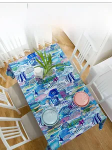 Close-up of thick cotton tablecloth with vibrant tropical fish pattern on a wooden table