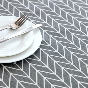 Detail of grey and white herringbone table cloth with subtle woven texture and cutlery