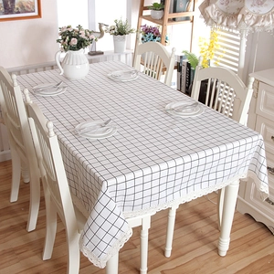 Modern black and white plaid rectangular tablecloth with white lace edges on dining table