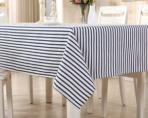 Detail view of blue and white striped fabric tablecloth with high-quality stitching on table